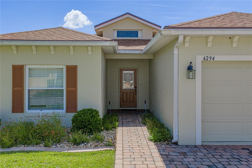 The exterior of a single-story house features a brick walkway leading to the front door — 4294 BERWICK DRIVE, LAKE WALES, FL