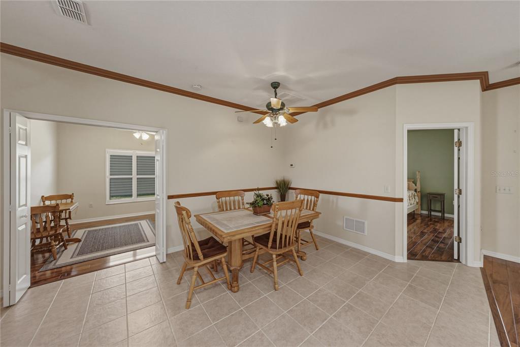 A dining room with tile flooring, a wooden table, and a ceiling fan — 4294 BERWICK DRIVE, LAKE WALES, FL
