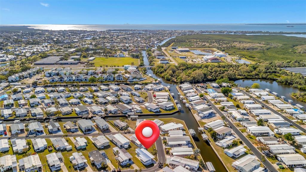 An aerial view shows a dense residential community of manufactured homes situated along narrow canals — 128 E SAINT JOHNS WAY, APOLLO BEACH, FL