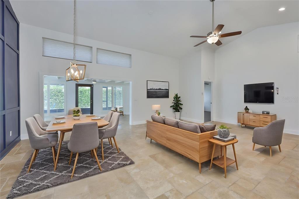 A spacious room features light tile flooring, a blue accent wall, and a kitchen pass-through — 14651 VILLAGE GLEN CIRCLE, TAMPA, FL