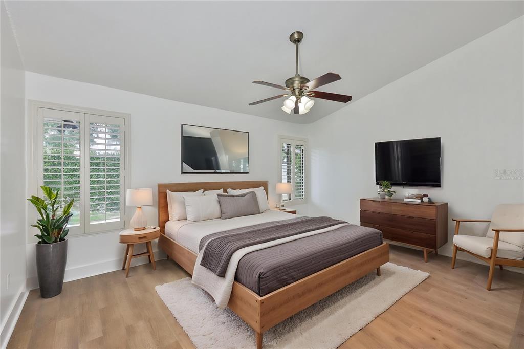 An empty room features light wood-look flooring, white walls, a ceiling fan, and two doorways — 14651 VILLAGE GLEN CIRCLE, TAMPA, FL