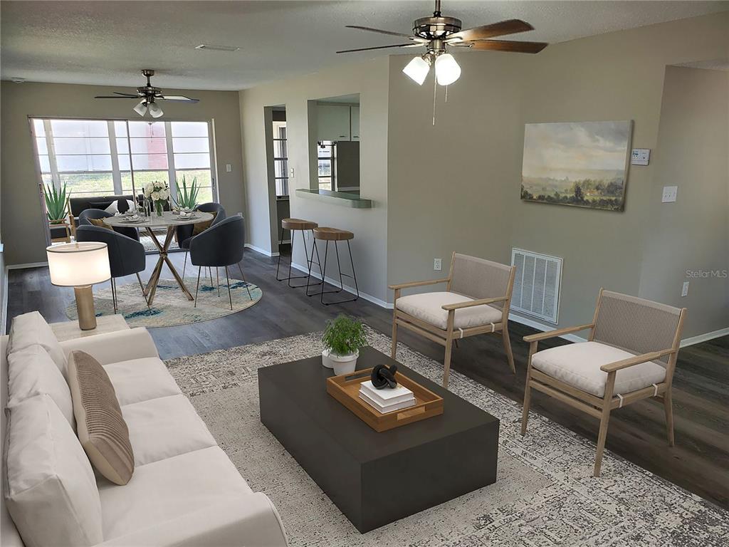 A living room and dining area feature gray wood-look flooring, neutral walls, and ceiling fans — 3936 SAILMAKER LANE, HOLIDAY, FL