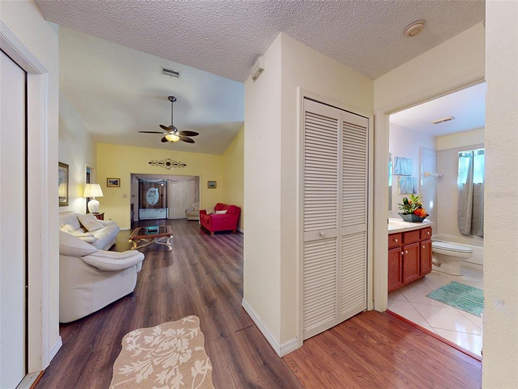 A view from a hallway looking into a living room and a bathroom with tile — 686 MIDDLEBURY LOOP, NEW SMYRNA BEACH, FL