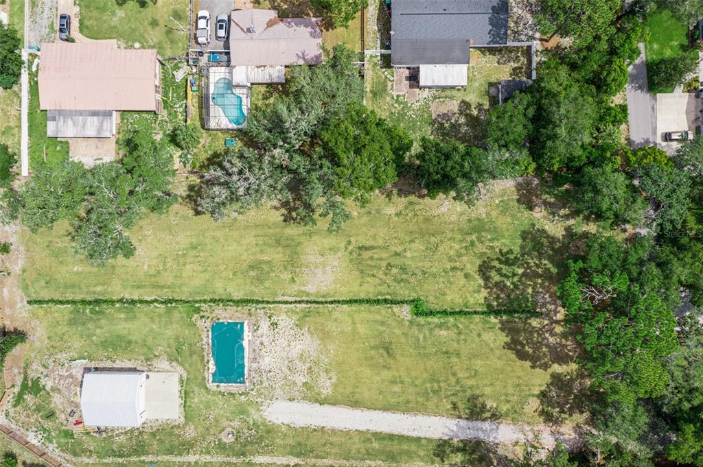 An aerial view shows a large grassy lot with a pool and a small building — 136 N 9TH STREET, LAKE MARY, FL