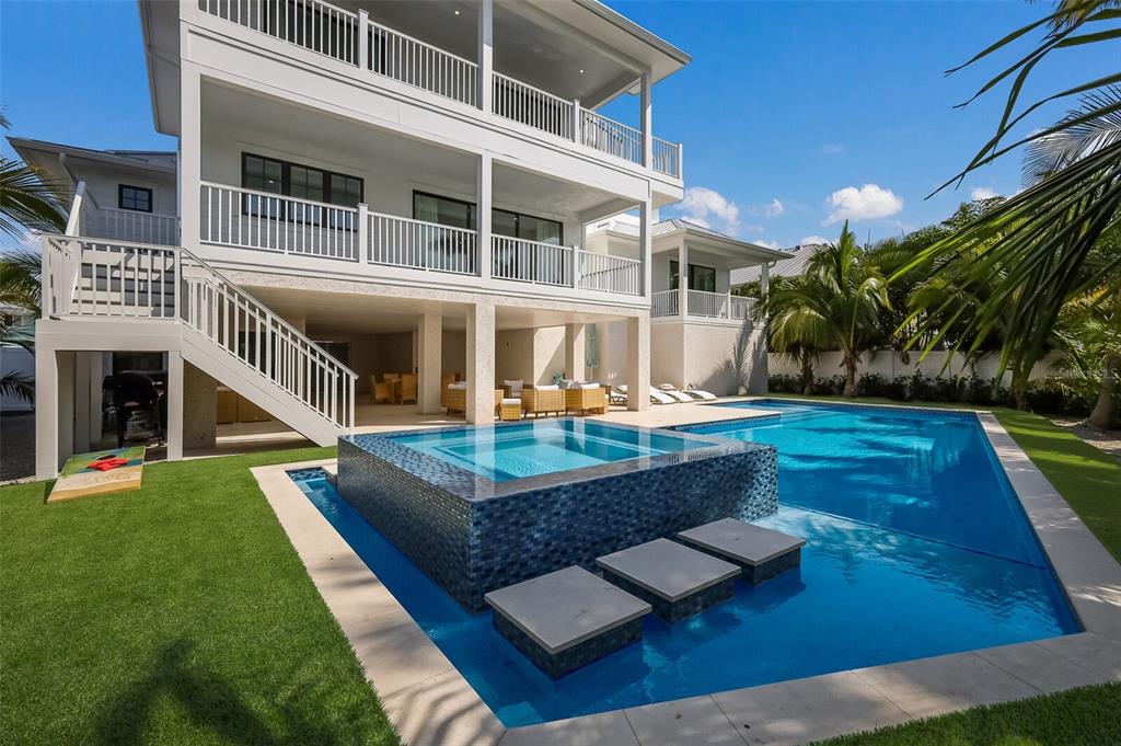 A multi-story white house with a pool, raised spa, and outdoor patio area — 227 S HARBOR DRIVE, HOLMES BEACH, FL