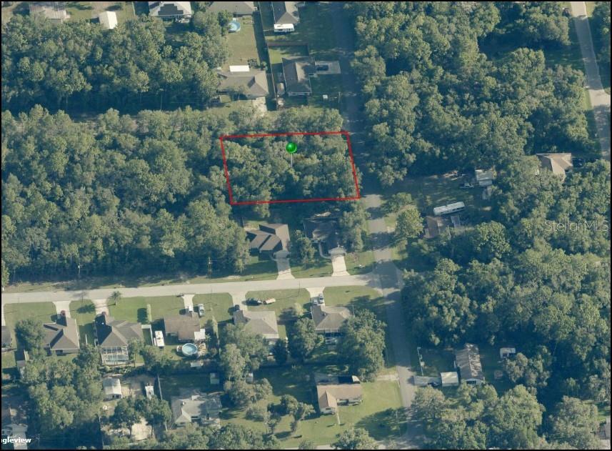 An aerial view shows a rectangular, wooded vacant lot outlined in red — 3348 E HESTER STREET, INVERNESS, FL