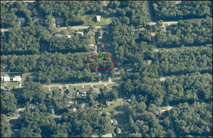 This aerial view shows a wooded, rectangular vacant lot outlined in red — 3348 E HESTER STREET, INVERNESS, FL