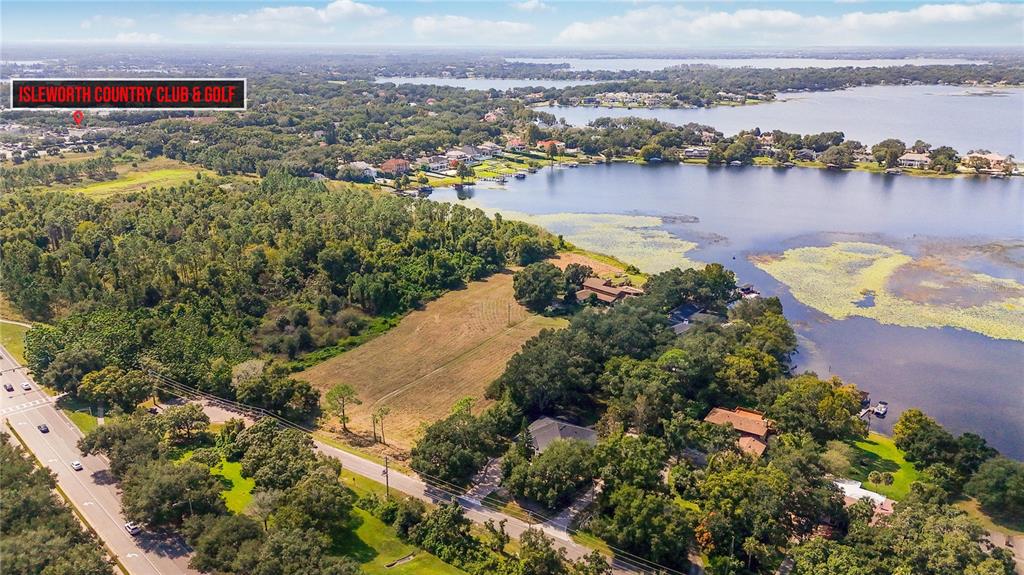 An aerial view shows a large, grassy lot situated next to a lake and trees — 4226 DOWNEAST LANE, WINDERMERE, FL
