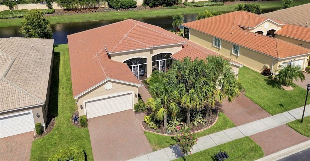 An aerial view shows a single-story house with a tile roof, garage, and palm trees — 4874 MARBLE SPRINGS CIRCLE, WIMAUMA, FL