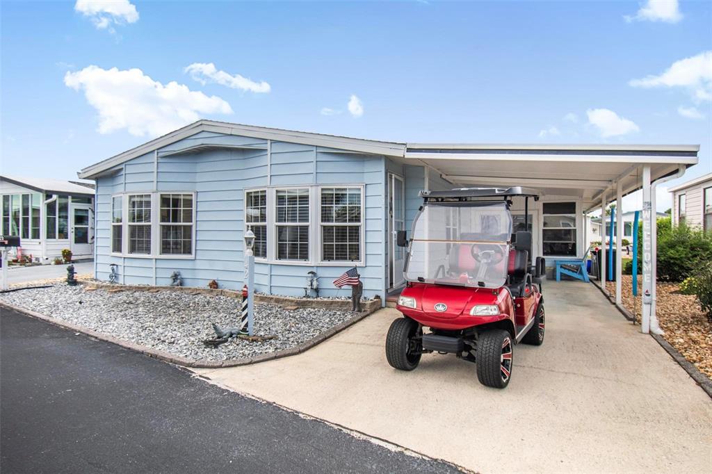 A light blue manufactured home with a carport and a red golf cart parked outside — 42 NAUTILUS DRIVE, FLAGLER BEACH, FL