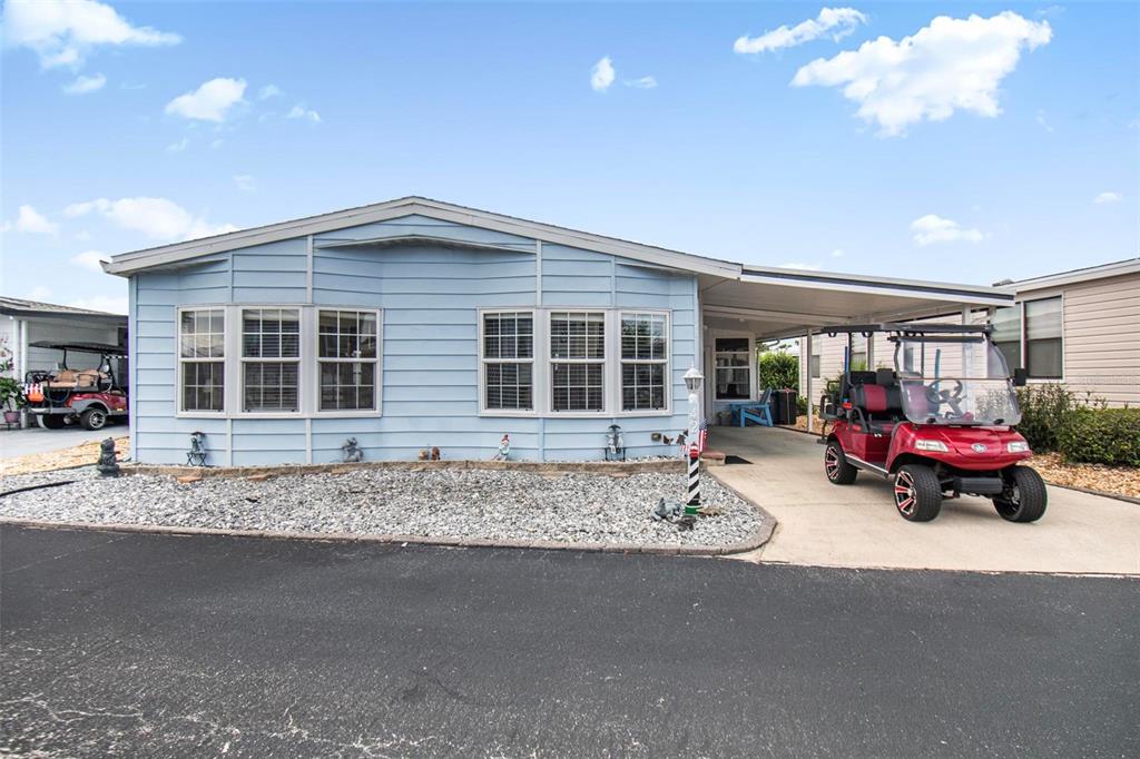 A light blue manufactured home with a carport and a red golf cart parked outside — 42 NAUTILUS DRIVE, FLAGLER BEACH, FL