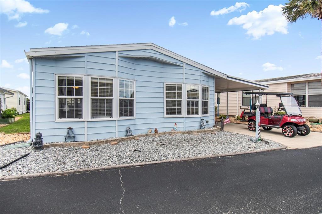 A light blue mobile home with a gravel front yard and a red golf cart — 42 NAUTILUS DRIVE, FLAGLER BEACH, FL