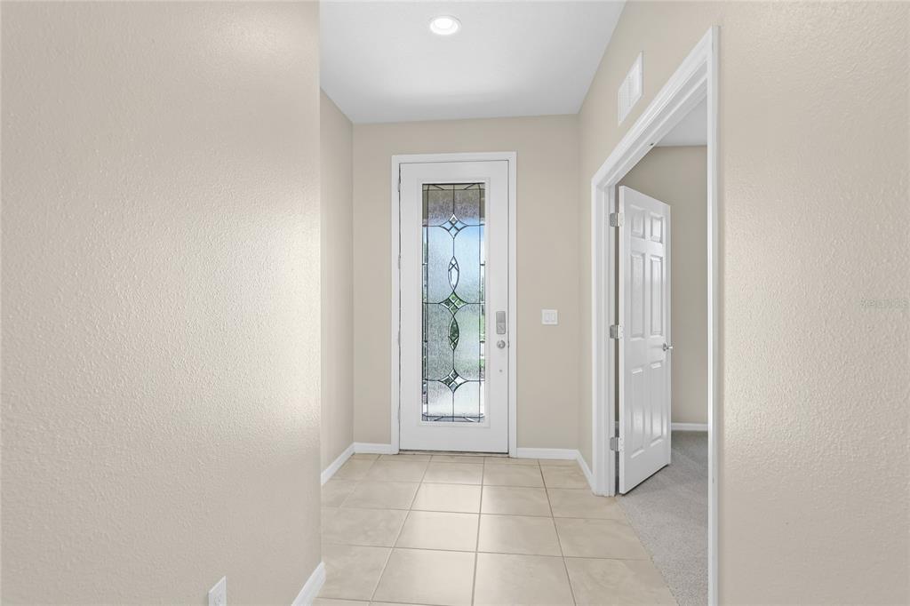 A tiled entryway features a white front door with decorative glass and an adjacent doorway — 6574 KENAVA LOOP, PALMETTO, FL
