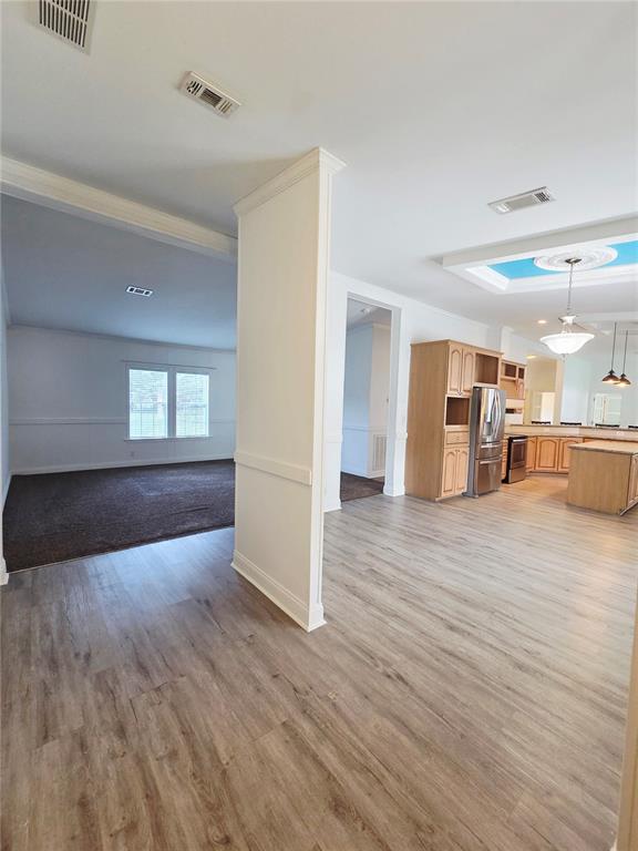 A view of a kitchen with wood cabinets and a living area with carpet — 6607 IVY MIST LANE, DAVENPORT, FL