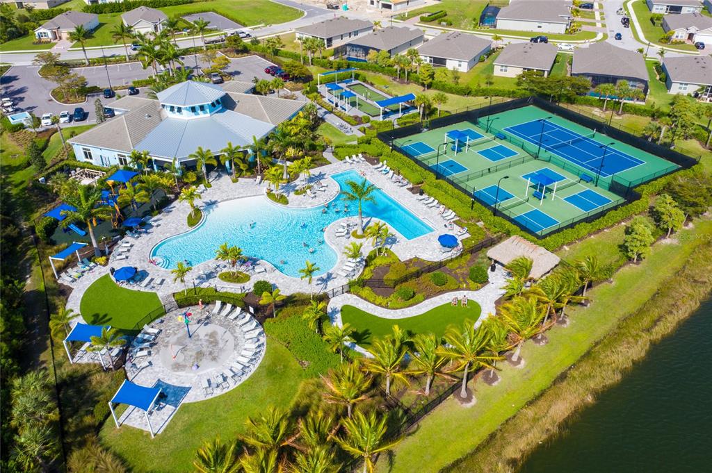 An aerial view of a community clubhouse with a pool, tennis courts, and surrounding homes — 3286 BARAVALDO CIRCLE, CAPE CORAL, FL