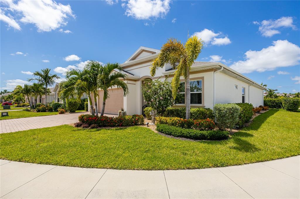A single-story house with a beige exterior, a two-car garage, and palm trees in front — 3286 BARAVALDO CIRCLE, CAPE CORAL, FL
