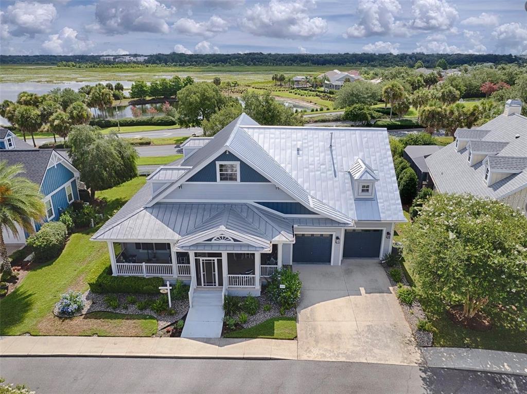 A spacious open-concept living room features a large sectional sofa, wood-look flooring, and media cabinetry — 1040 COTTAGE DRIVE, THE VILLAGES, FL