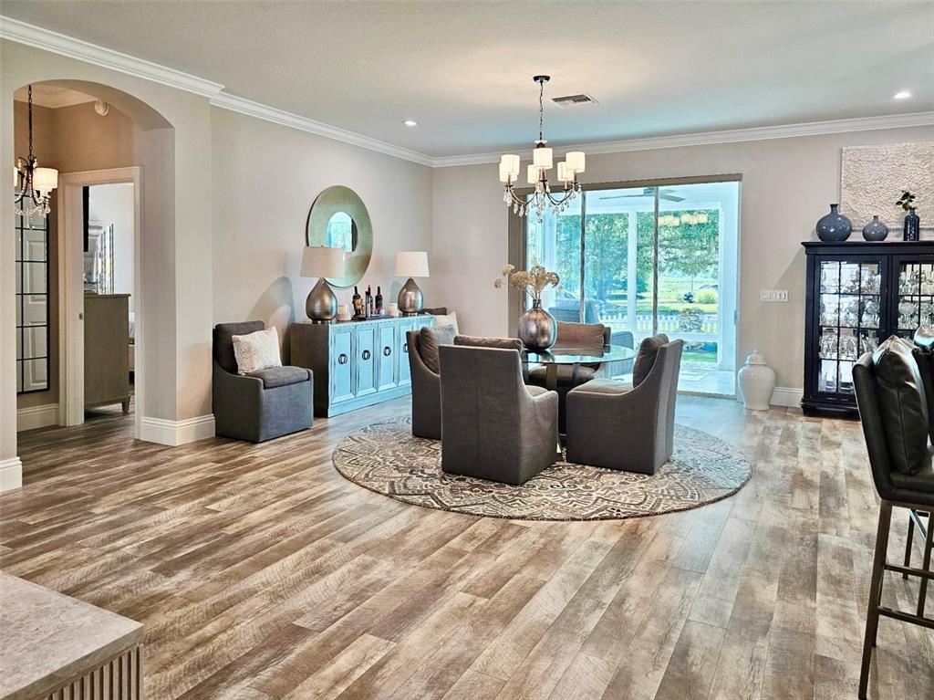 A kitchen features dark cabinetry, granite countertops, stainless steel appliances, and a breakfast bar — 1040 COTTAGE DRIVE, THE VILLAGES, FL