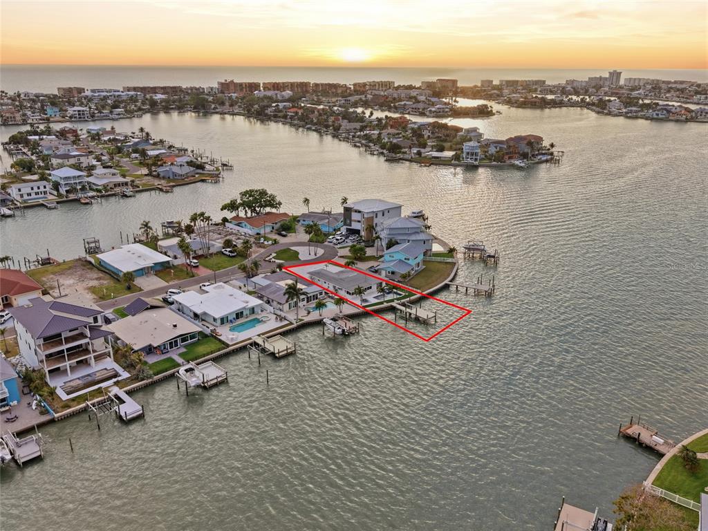 An aerial view shows a waterfront house with a private dock on a canal — 16113 5TH STREET E, REDINGTON BEACH, FL