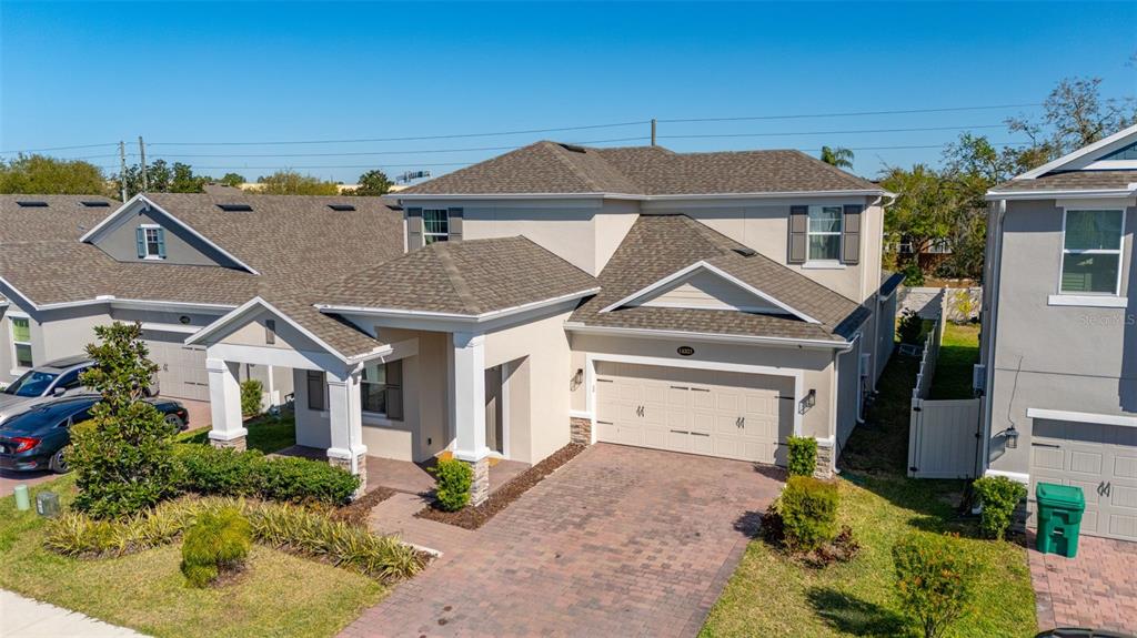 An aerial view of a two-story suburban house with a brick driveway and garage — 14321 WABASSO LOOP, WINTER GARDEN, FL