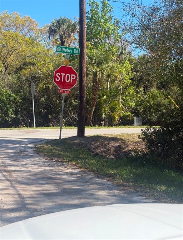 A stop sign and a Weber Rd street sign stand on a wooden utility pole — 3305 WEBER ROAD, GRANT VALKARIA, FL