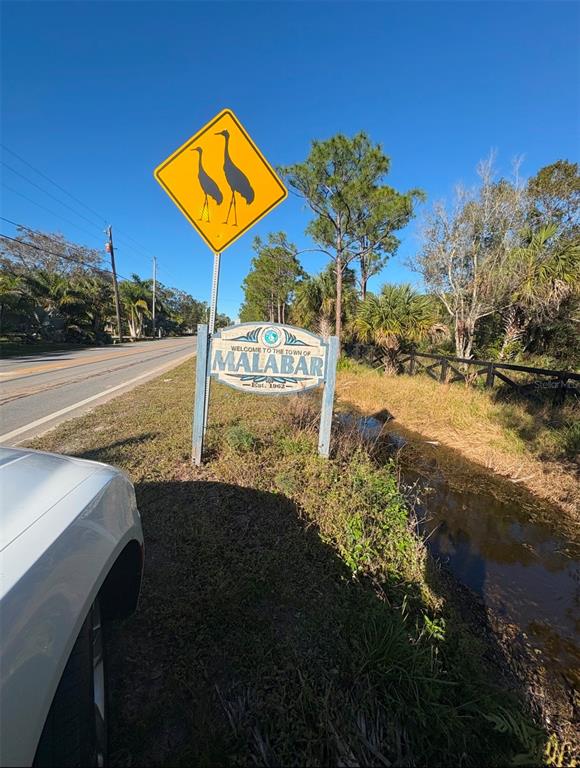 A road sign welcoming visitors to the town of Malabar stands beside a roadside ditch — 3305 WEBER ROAD, GRANT VALKARIA, FL