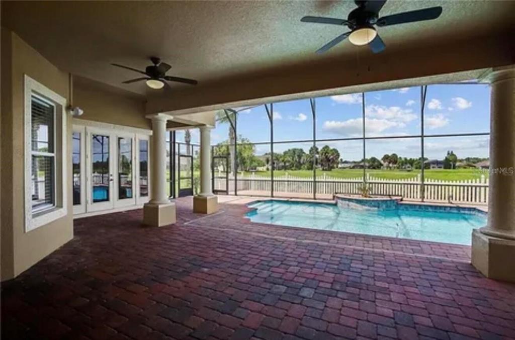 An aerial view of a yellow house with a pool cage situated on a golf course — 2120 BUNKER VIEW COURT, KISSIMMEE, FL