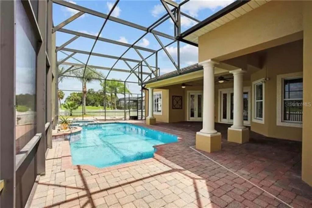 An aerial view shows a suburban neighborhood with houses situated along a golf course pond — 2120 BUNKER VIEW COURT, KISSIMMEE, FL