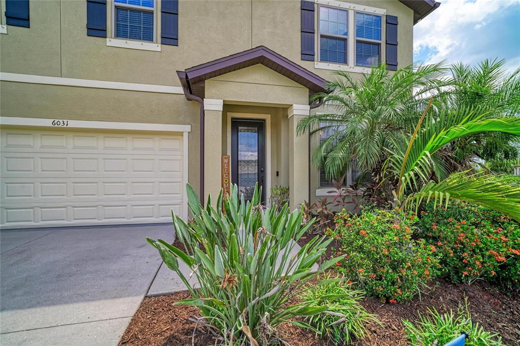The exterior of a two-story house features a garage, a front entrance, and landscaping — 6031 100TH AVENUE E, PARRISH, FL
