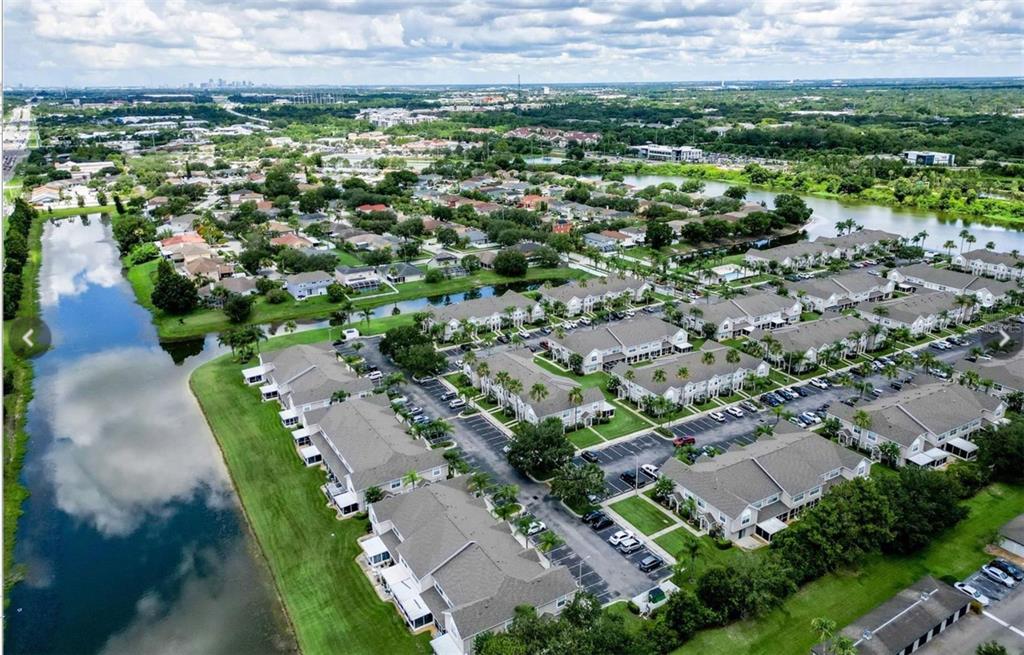 An aerial view of a residential townhouse community featuring multiple buildings, parking lots, and ponds — 734 KENSINGTON LAKE CIR UNIT BRANDON, BRANDON, FL