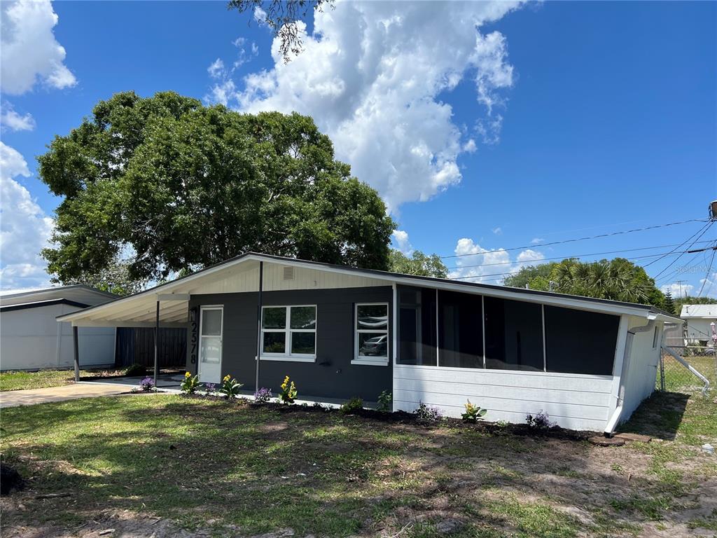 A single-story house with a dark gray facade, a carport, and a screened-in porch — 2578 COVENTRY ROAD, MELBOURNE, FL