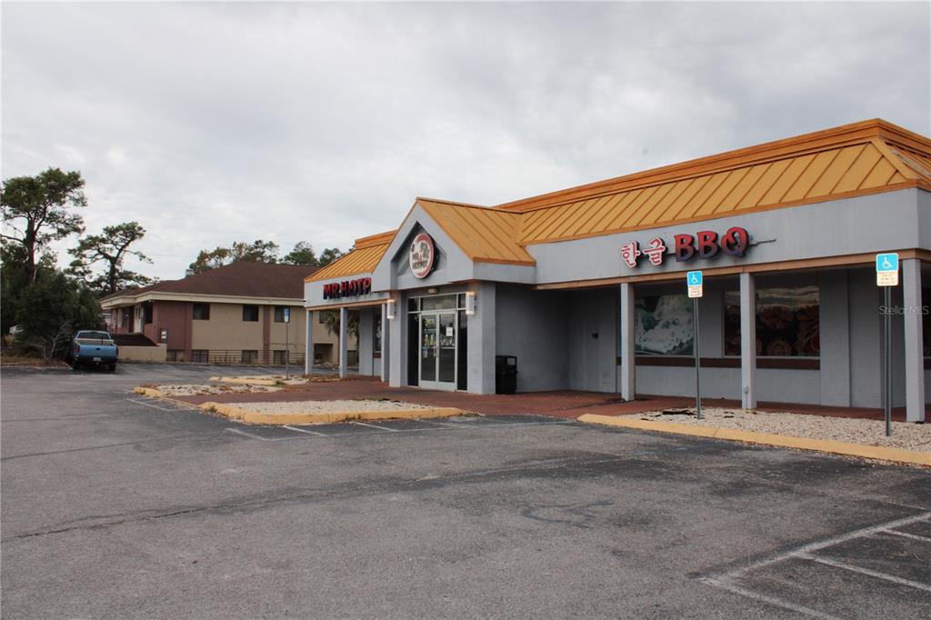 A commercial building with a yellow metal roof and signage for a restaurant — COMMERCIAL WAY, SPRING HILL, FL