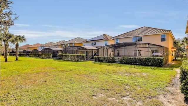 The exterior view shows the back of several suburban houses with screened-in lanais and lawns — 4352 ACORN COURT, DAVENPORT, FL