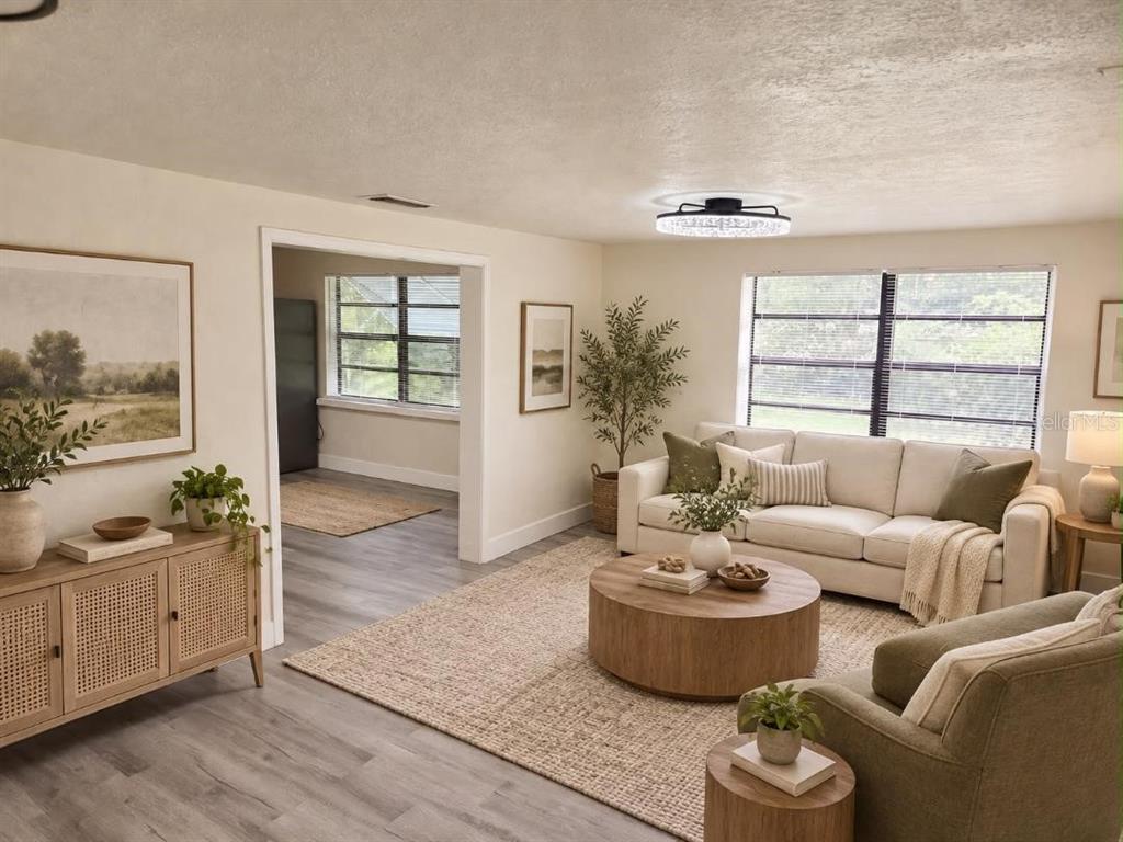 A living room features light wood flooring, a beige sofa, and a round wooden coffee table — 234 E LADY LAKE BOULEVARD, LADY LAKE, FL