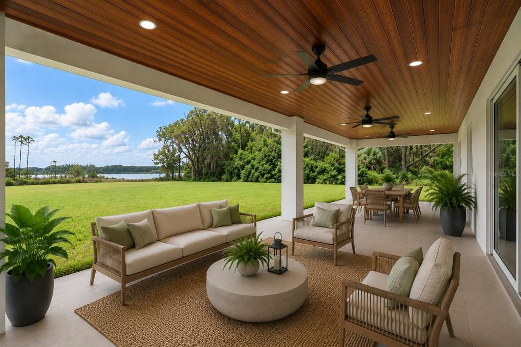 A covered outdoor patio features a wood-paneled ceiling, ceiling fans, and views of a lake — 39251 COUNTY ROAD 439, UMATILLA, FL