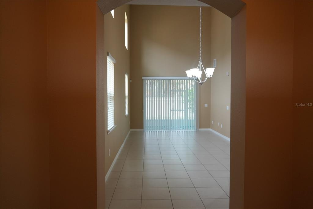 An empty room with high ceilings, tile flooring, a chandelier, and sliding glass doors — 2212 LENNOX DALE LANE, BRANDON, FL