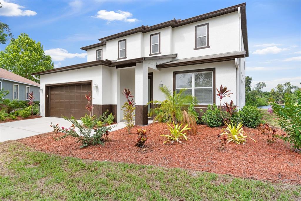 A two-story house with white stucco walls, brown trim, and a front-facing garage — 5424 HAMMOCK VIEW LANE, APOLLO BEACH, FL