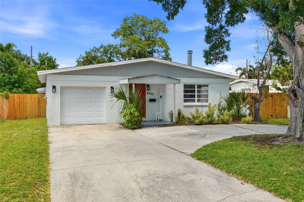 A single-story house with a white stucco exterior, a one-car garage, and a concrete driveway — 4027 HUNTINGTON STREET NE, ST PETERSBURG, FL