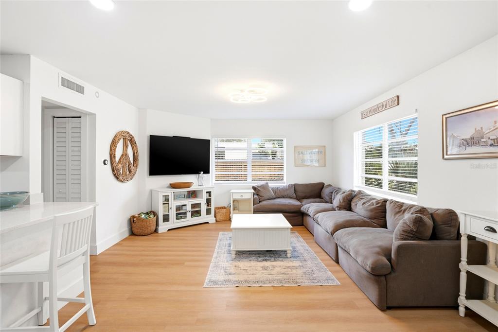 A living room features a large brown sectional sofa, a white coffee table, and a television — 4027 HUNTINGTON STREET NE, ST PETERSBURG, FL