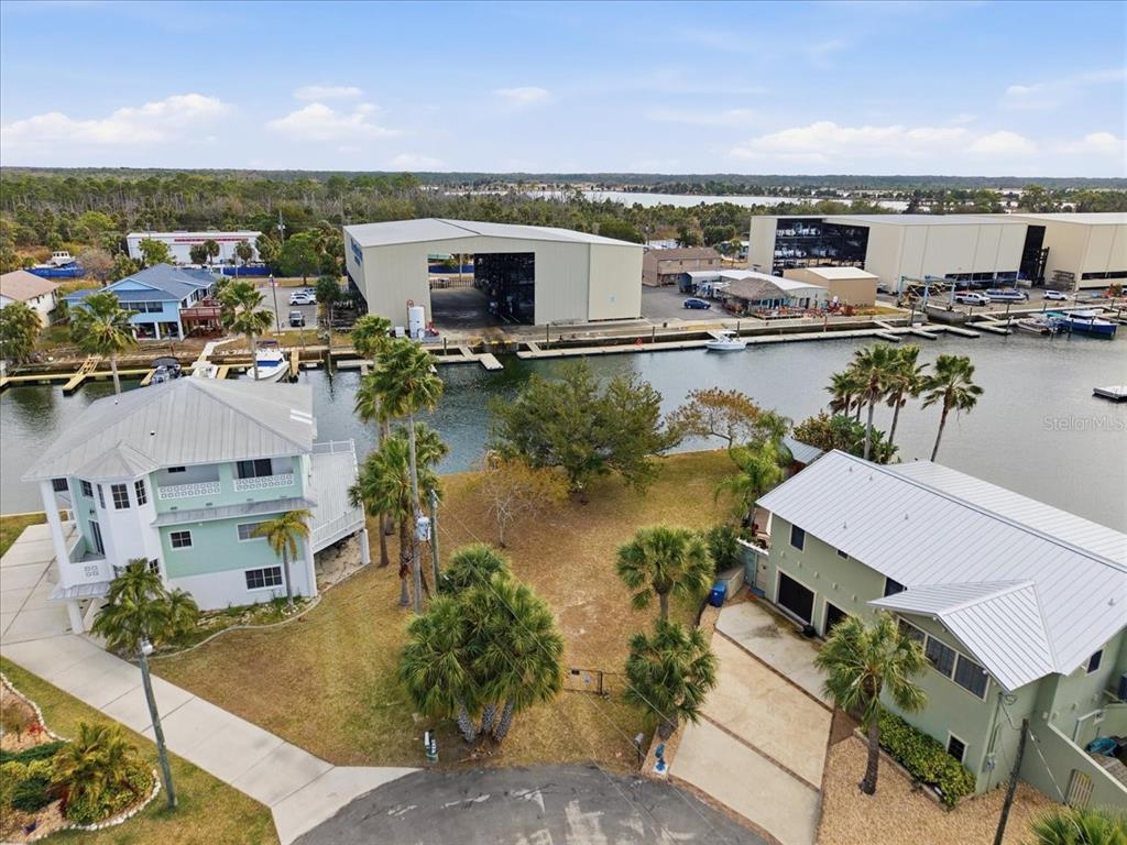 An aerial view shows two houses separated by a grassy lot along a canal — 4064 CASA COURT, HERNANDO BEACH, FL