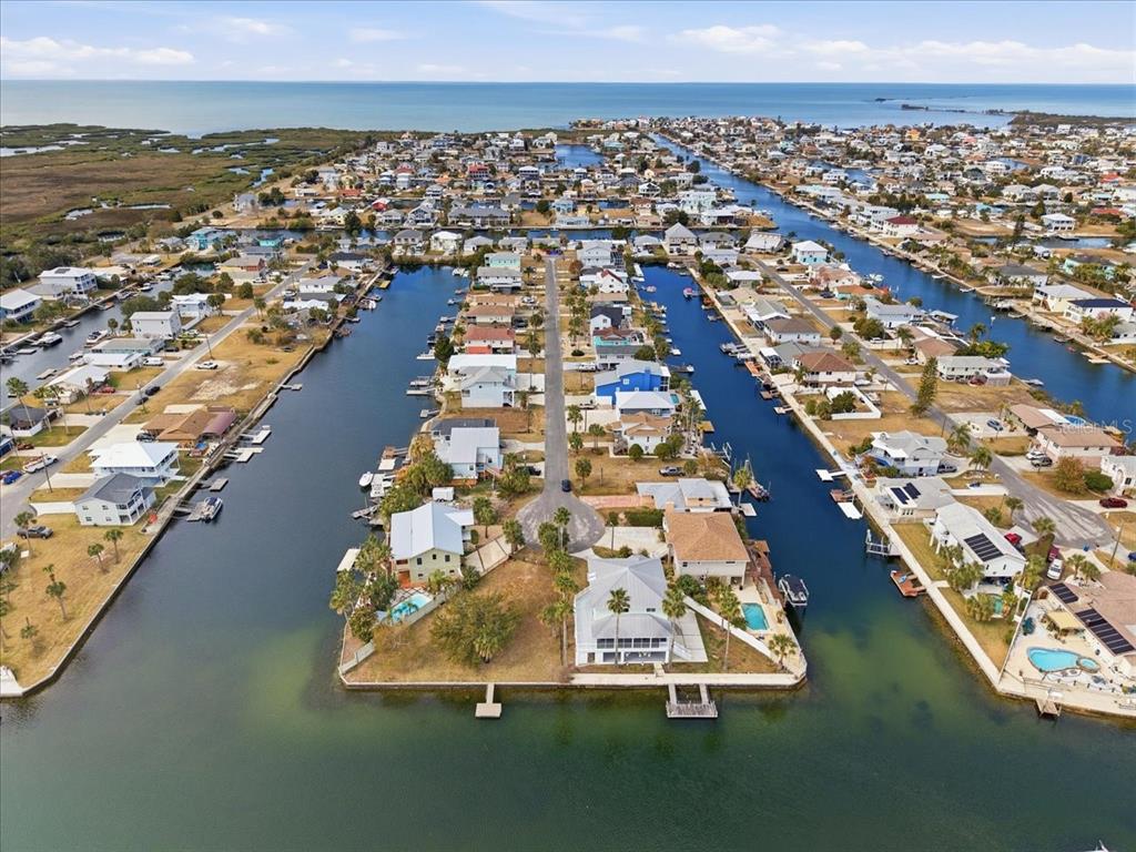 An aerial view shows waterfront houses along canals leading to the open sea — 4064 CASA COURT, HERNANDO BEACH, FL