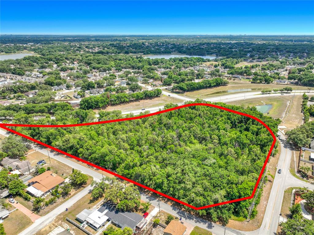 An aerial view shows a large, wooded, undeveloped lot outlined in red near residential streets — 1900 E SILVER STAR ROAD, OCOEE, FL