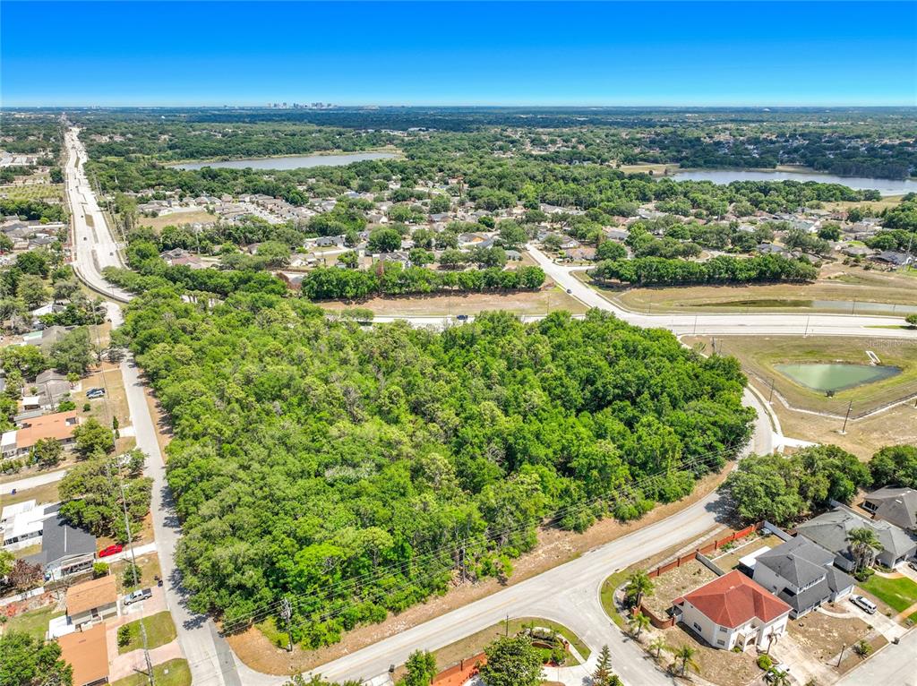 An aerial view shows a large, wooded vacant lot surrounded by suburban houses and roads — 1900 E SILVER STAR ROAD, OCOEE, FL