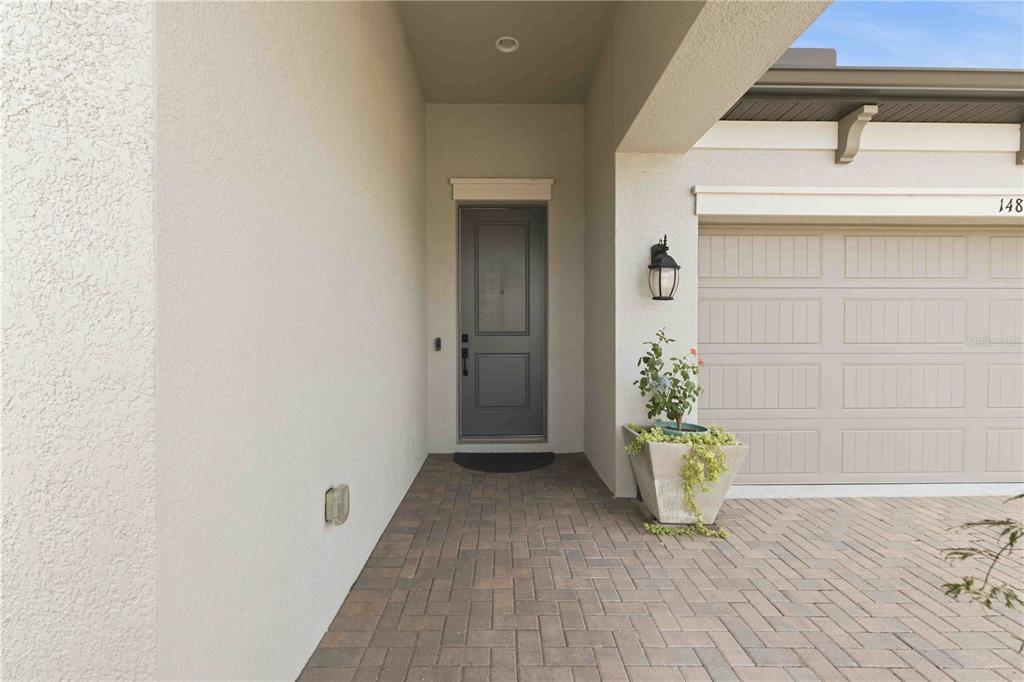 A hallway features a wooden console table, framed wall art, and light wood-look flooring — 14814 SORA WAY, BRADENTON, FL