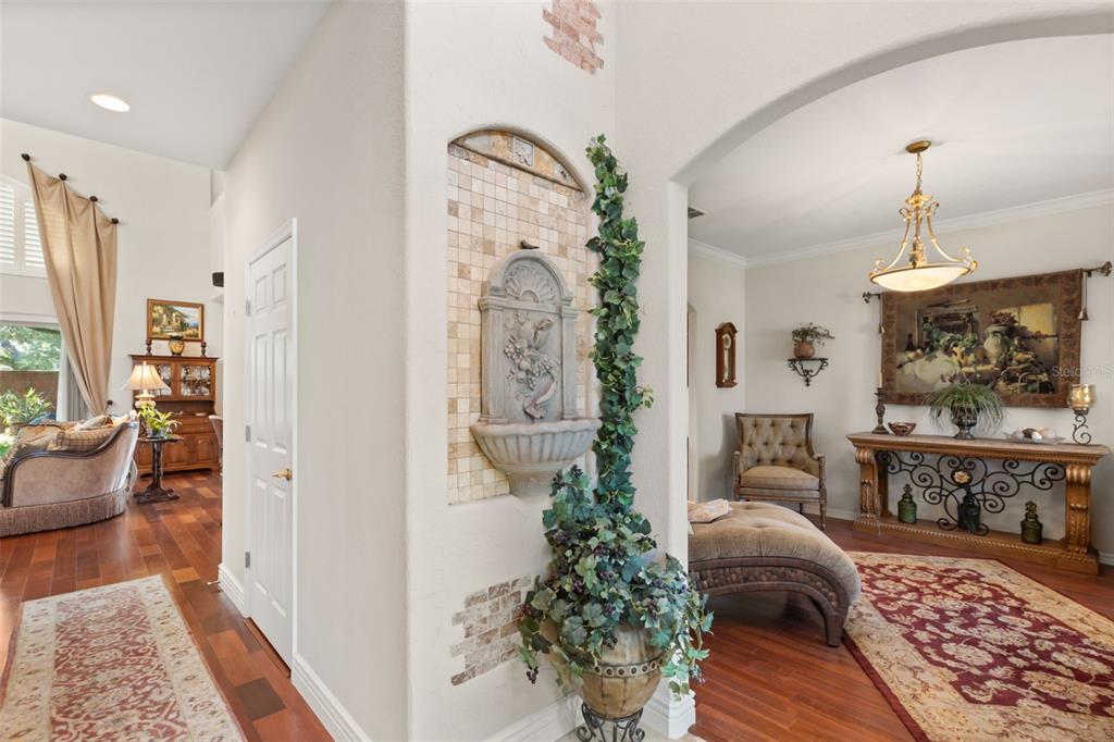 A wall-mounted fountain with tile accents stands between a living room and a dining area — 393 LAKE AMBERLEIGH DRIVE, WINTER GARDEN, FL