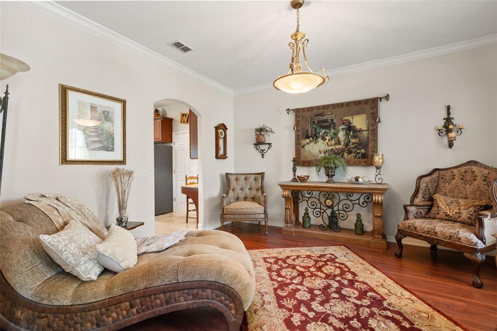 A living room features a chaise lounge, patterned armchairs, a console table, and hardwood floors — 393 LAKE AMBERLEIGH DRIVE, WINTER GARDEN, FL
