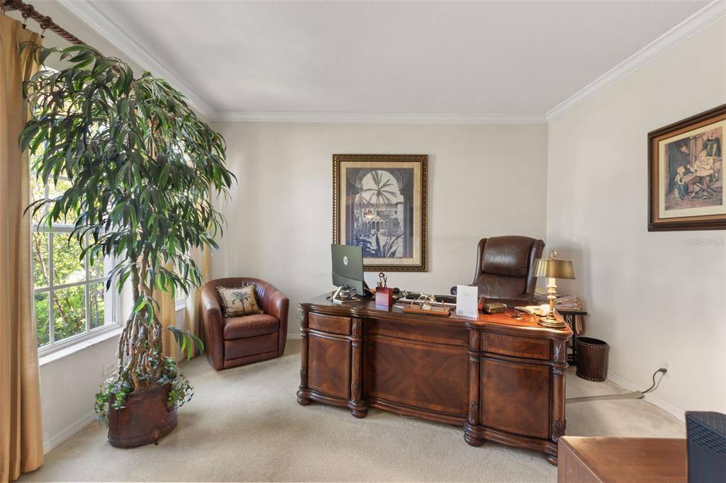 A home office features a large wooden desk, a leather chair, and a potted plant — 393 LAKE AMBERLEIGH DRIVE, WINTER GARDEN, FL