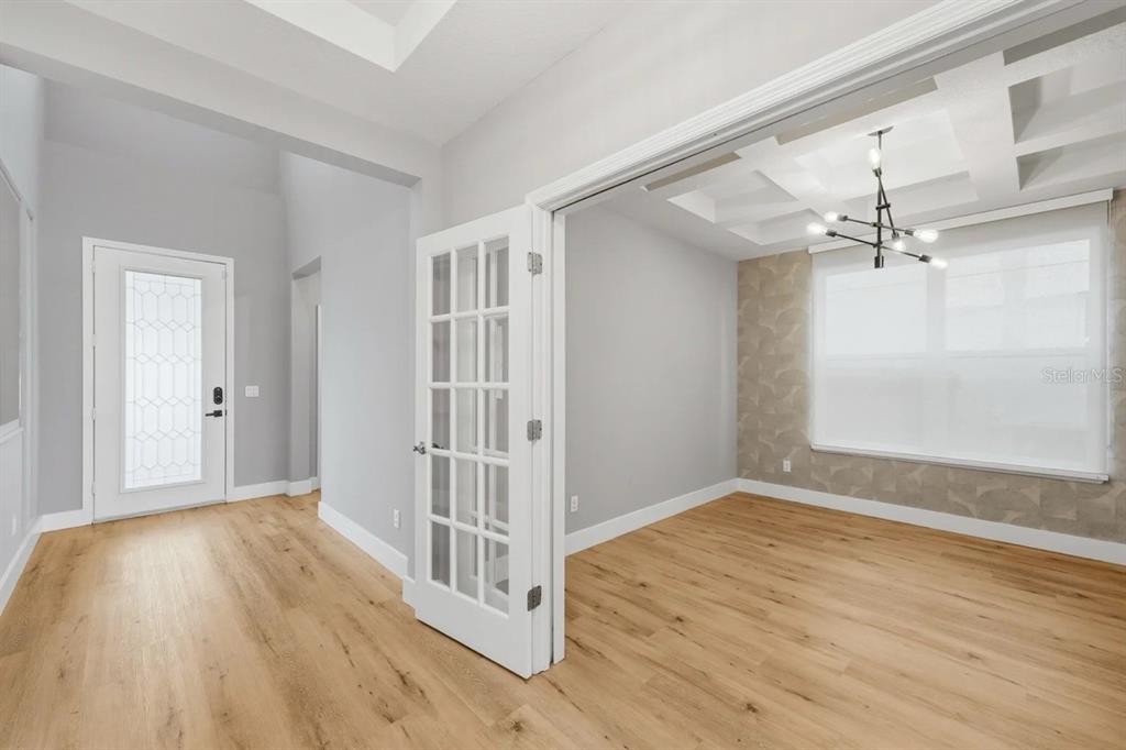 A bright room with light wood floors, French doors, and a coffered ceiling with chandelier — 5024 PALMETTO PARK DRIVE, WINTER GARDEN, FL
