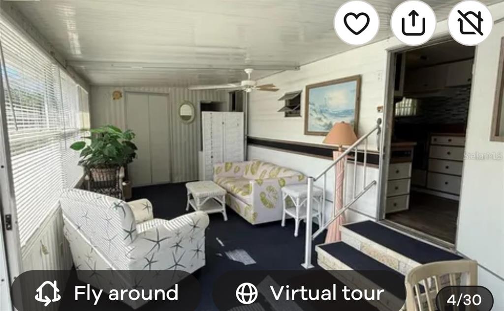 A sunroom features a sofa, armchair, white wicker tables, and a ceiling fan — 1475 FLAMINGO DRIVE UNIT 162, ENGLEWOOD, FL