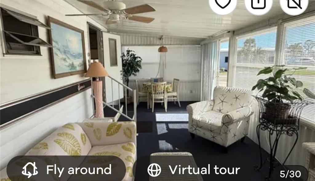 A sunroom features a ceiling fan, patterned furniture, a dining set, and large windows — 1475 FLAMINGO DRIVE UNIT 162, ENGLEWOOD, FL